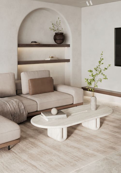 A modern living room with a beige sectional sofa, white oval coffee table, built-in shelves, decorative plants, and minimalistic decor.
